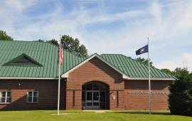 A front view of the HUdson Police Department with American flag and State flag