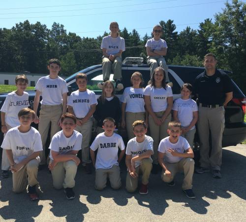 2017 Youth Police Academy Class posing infront of marked police cruiser