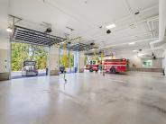 Polished concrete floor in a large open bay with bay doors open and fire truck parked in last bay.