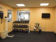 Fitness Room with orange walls, tv and rack with weights