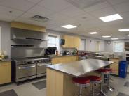 Large open kitchen with large stainless steel stove and counter top