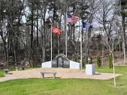 Side view of the firefighters memorial.  Green grass, granite benches and granite memorial.