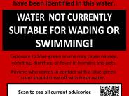 Red sign noting due to a cyanobacteria advisory, water is not currently suitable for wading or swimming