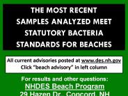 Green sign noting that the most recent samples analyzed meet statutory bacteria standards for beaches.