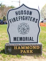 Granite stone reading Hudson Firefighters Memorial with logo in middle sitting on a marble stone with the words Hammond Park.