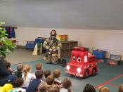 One of our firefighters in his protective gear alongside Freddie the Fire Truck.