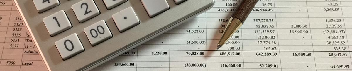 spreadsheet with columns and figures, calculator and pen